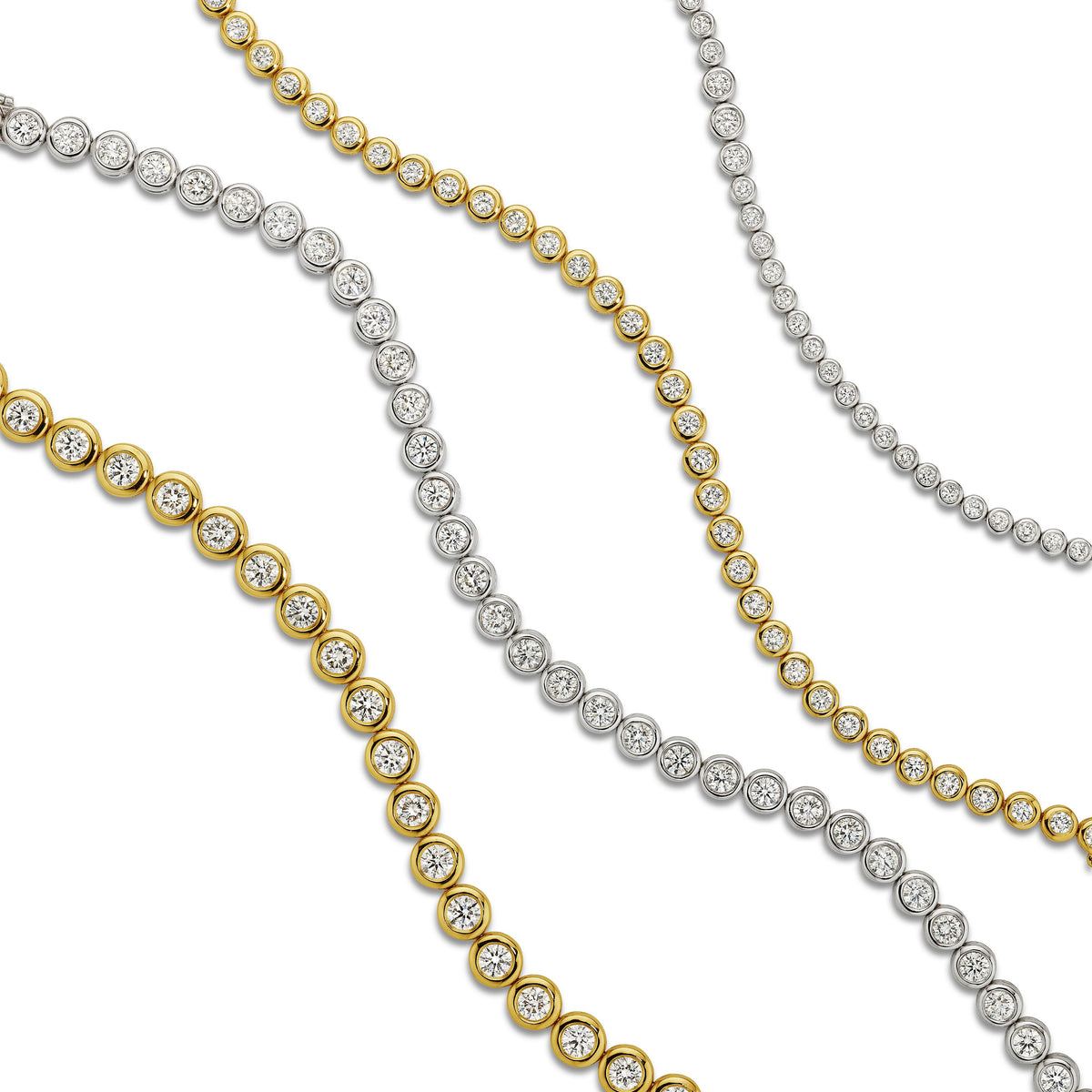 Bezel set diamond tennis bracelets in 18k white and yellow gold, group shot