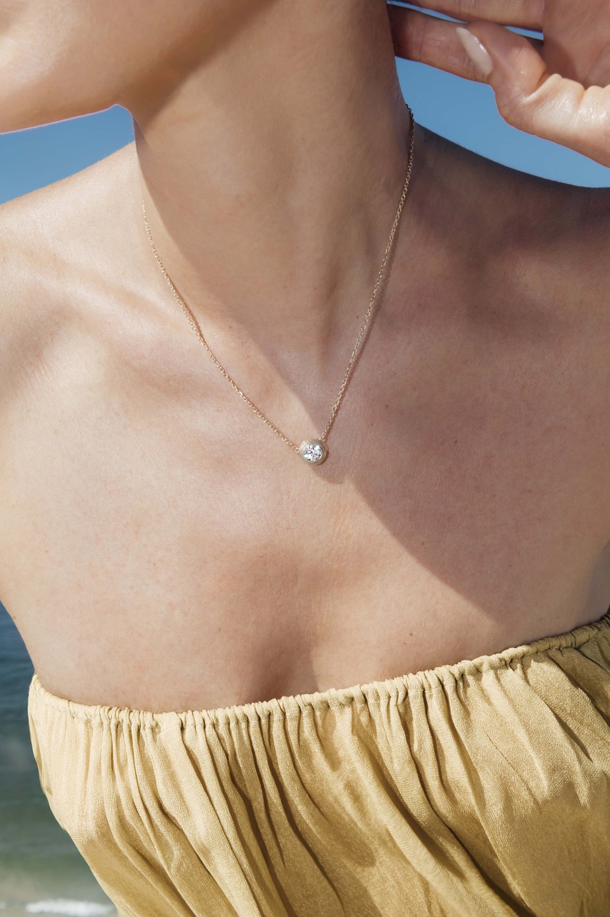 Triple bezel 1 carat round diamond pendant necklace in 18k yellow gold, worn