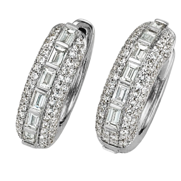 A pair of silver hoop earrings paved with small clear stones and featuring a central row of larger baguette-cut clear stones, shown on a white background.